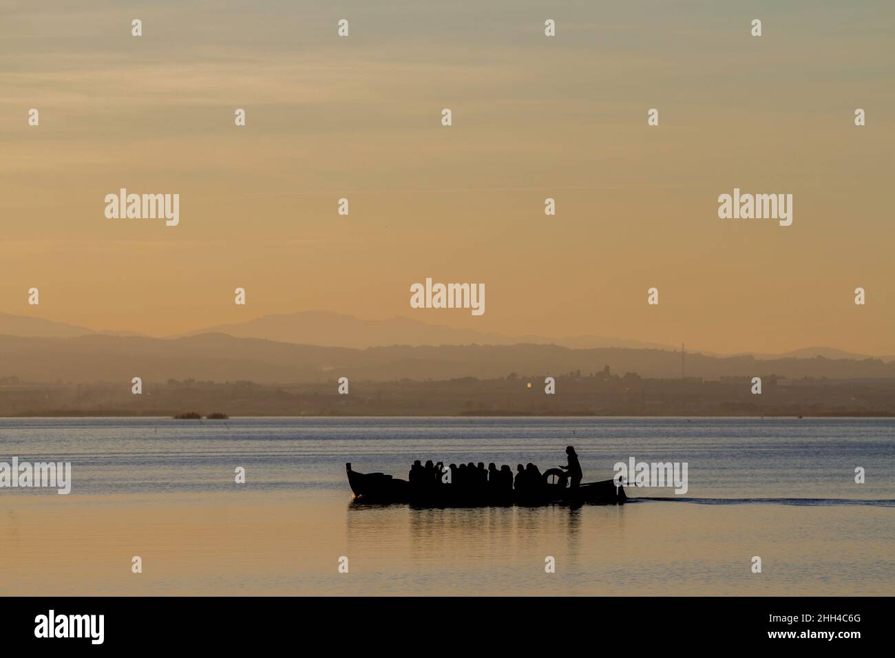La barca tradizionale dal lago Albufera di Valencia in Spagna trasporta i turisti per osservare la bellezza del tramonto nell'ora d'oro Foto Stock