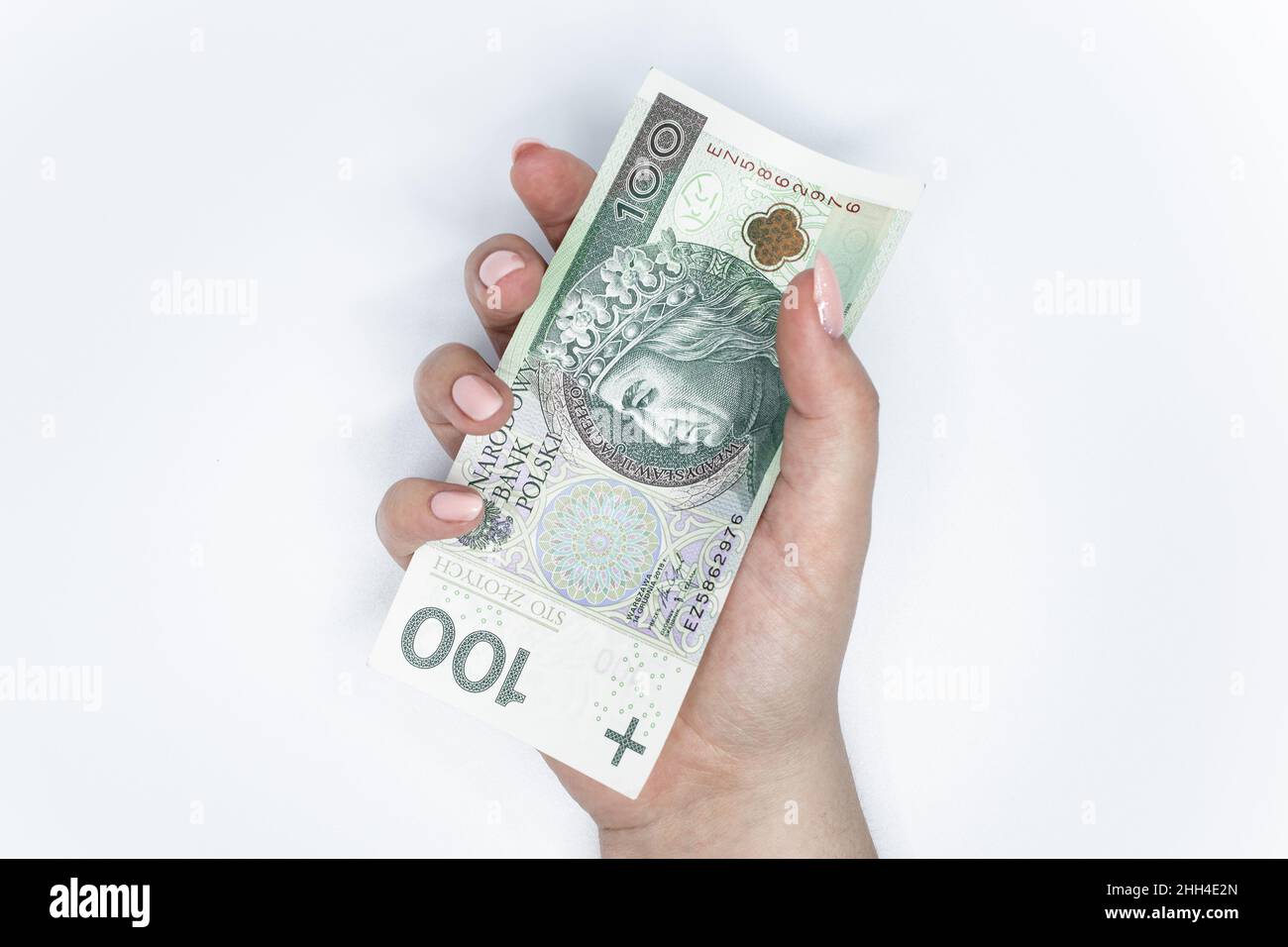 Cento zloty - banconota polacca. Valuta polacca tenuta in mano su sfondo bianco Foto Stock