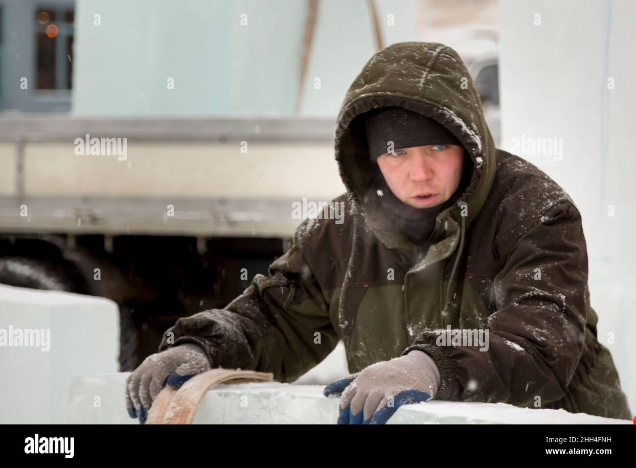Close-up di un lavoratore del volto con un cappuccio sulla sua testa Foto Stock