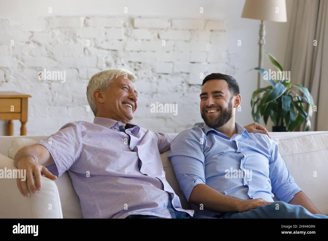 Felice padre anziano gioioso e figlio grownup scherzando e ridendo Foto Stock