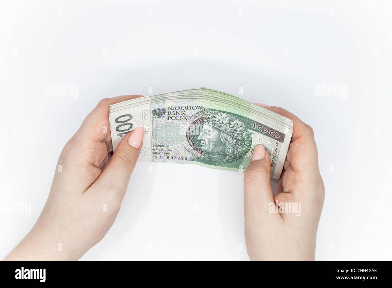 Cento zloty - banconota polacca. Valuta polacca tenuta in mano su sfondo bianco Foto Stock