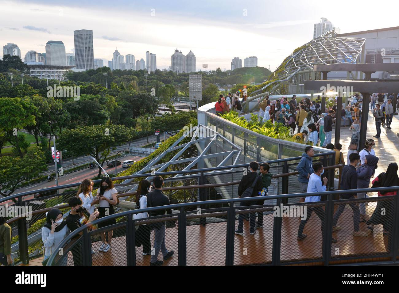 (220123) -- JAKARTA, 23 gennaio 2022 (Xinhua) -- la gente gode della vista della città sullo skywalk del parco di Senayan in Jakarta, Indonesia, 23 gennaio 2022. I legislatori indonesiani il 18 gennaio hanno approvato una legge sulla delocalizzazione della capitale della nazione nell'isola di Kalimantan, che il paese condivide i confini con la Malesia e Brunei, dall'isola più popolata di Java. Nusantara, che viene chiamata la nuova capitale, sarà costruita in due distretti a Kalimantan Est - Penajam Paser Utara e Kutai Kartanegara. Si prevede di occupare circa 256.000 ettari di terreno. Nusantara sarà il centro del governo, Whi Foto Stock