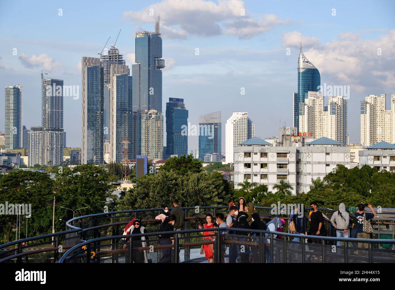 (220123) -- JAKARTA, 23 gennaio 2022 (Xinhua) -- la gente gode della vista della città sullo skywalk del parco di Senayan in Jakarta, Indonesia, 23 gennaio 2022. I legislatori indonesiani il 18 gennaio hanno approvato una legge sulla delocalizzazione della capitale della nazione nell'isola di Kalimantan, che il paese condivide i confini con la Malesia e Brunei, dall'isola più popolata di Java. Nusantara, che viene chiamata la nuova capitale, sarà costruita in due distretti a Kalimantan Est - Penajam Paser Utara e Kutai Kartanegara. Si prevede di occupare circa 256.000 ettari di terreno. Nusantara sarà il centro del governo, Whi Foto Stock
