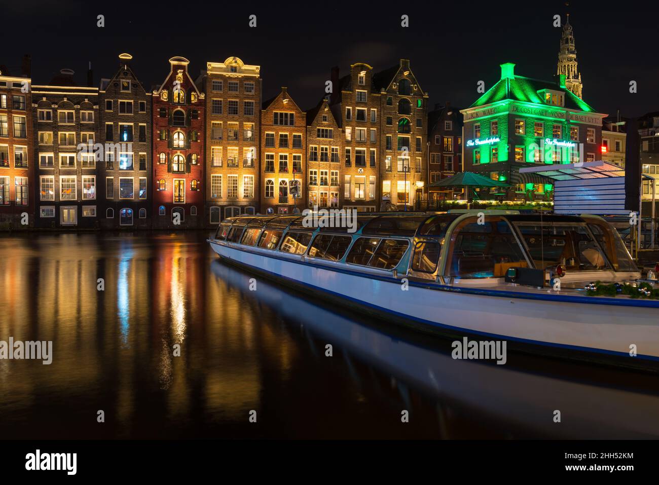 AMSTERDAM - 14 DICEMBRE 2019: Le famose case dei canali danzanti al canale Damrak di notte Foto Stock