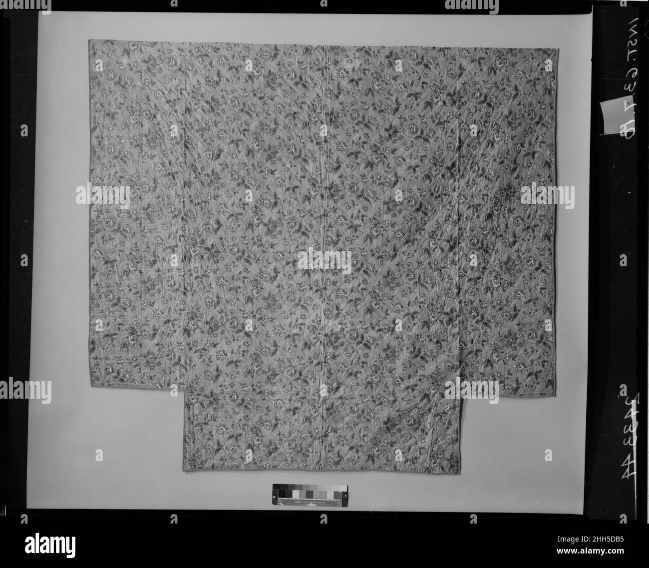 Trapunte in wholecloth ca. 1830 americano o britannico questo quilt di chintz è dentellato ai relativi angoli inferiori per accomodare i posti letto. Il quillo è legato con nastro di cotone striato in marrone chiaro, bianco, nero e blu. Il tessuto di cima chintz è decorato con sentieri floreali, rullo stampato in rosso e blocco sovrastampato in blu, giallo, e verde su una terra marrone chiaro. Il supporto chintz ha una flora / striscia, rullo stampato in rosso e marrone. Il pezzo è trapuntato tuta con un motivo shell. Trapunta in wholecloth. Americano o britannico. CA. 1830. Cotone. Possibilmente fabbricato in Inghilterra; possibilmente fabbricato negli Stati Uniti Foto Stock