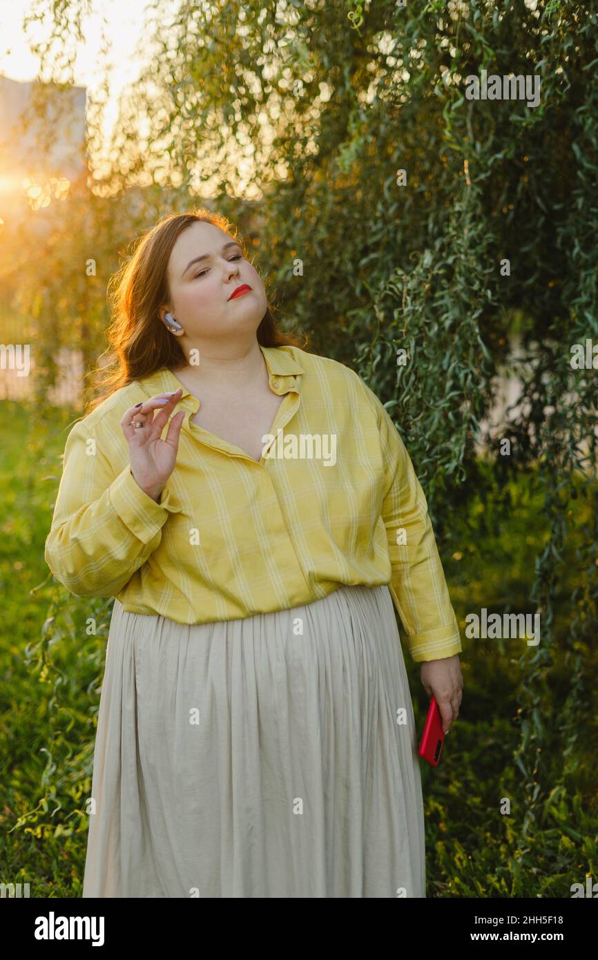 Donna che ascolta la musica con le cuffie auricolari wireless Foto Stock
