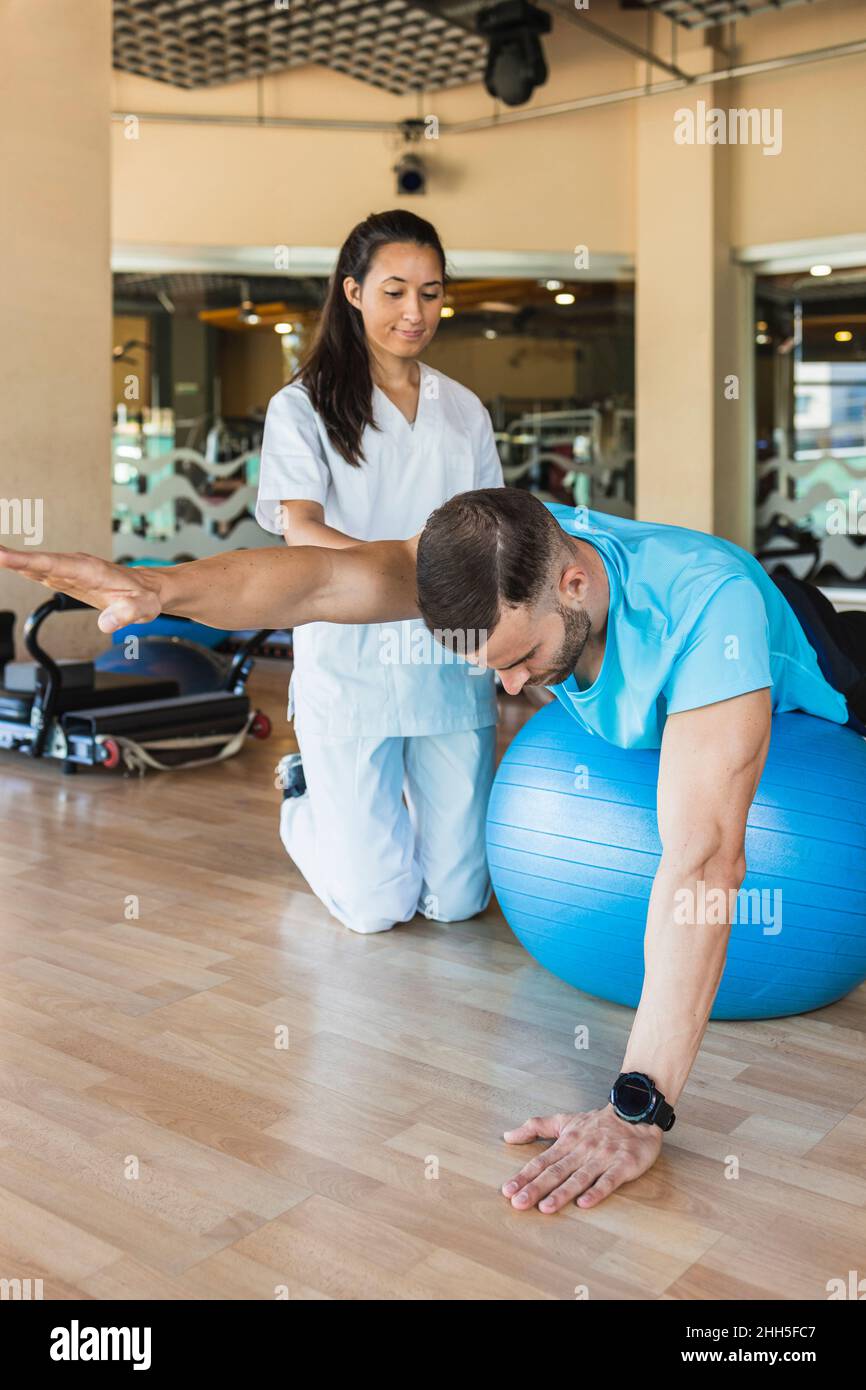 Atleta che si esercita sulla palla sportiva in palestra Foto Stock