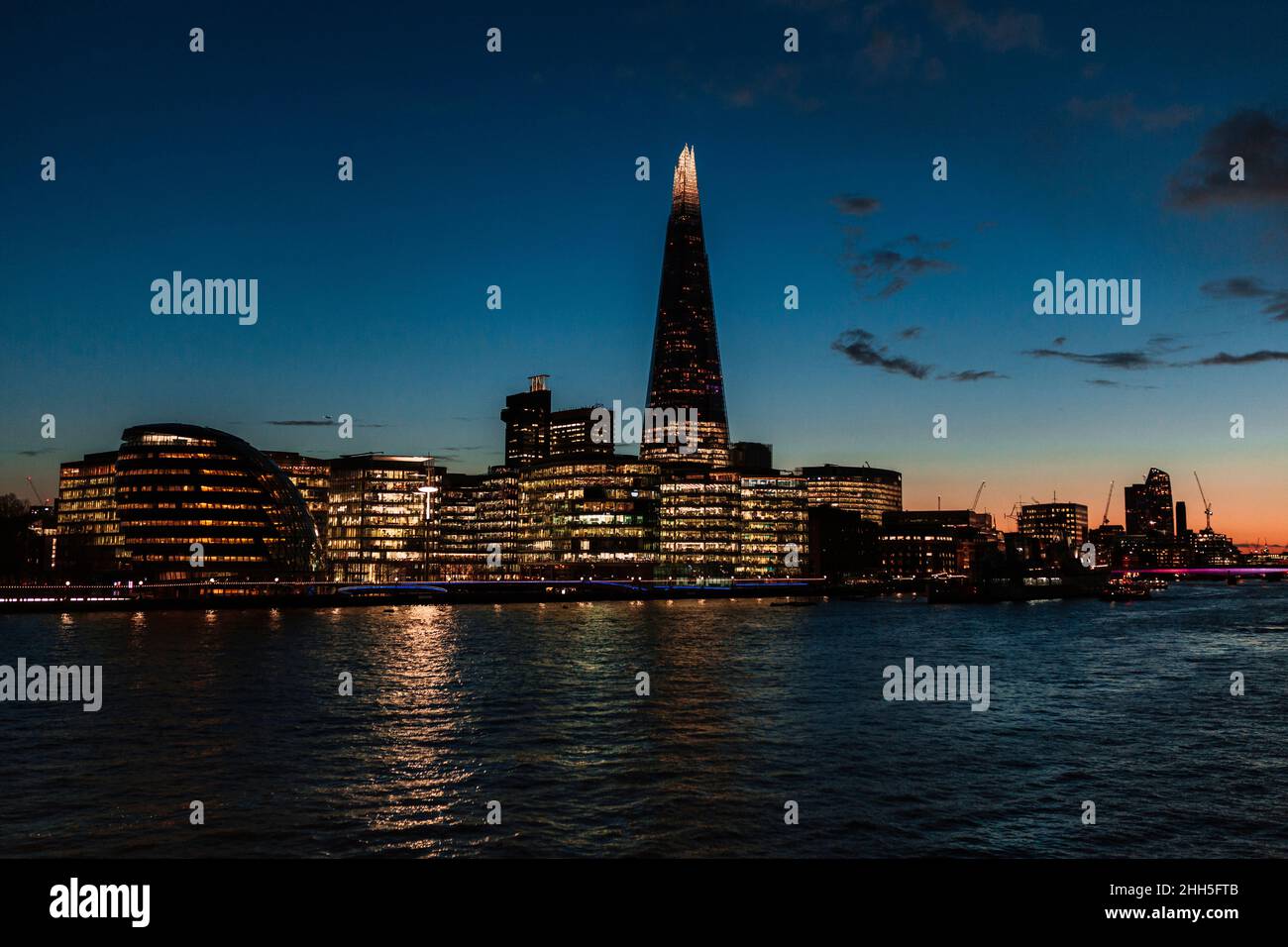 Edifici moderni illuminati sul Tamigi in città al tramonto, Londra, Inghilterra, Regno Unito Foto Stock