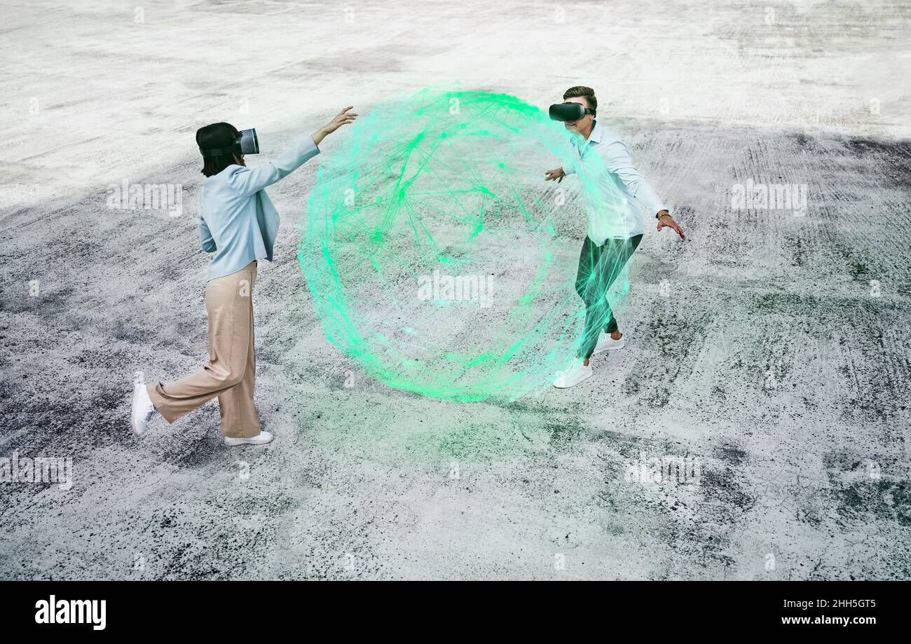 Amici che usano cuffie per realtà virtuale che giocano con una sfera verde brillante sul sentiero Foto Stock