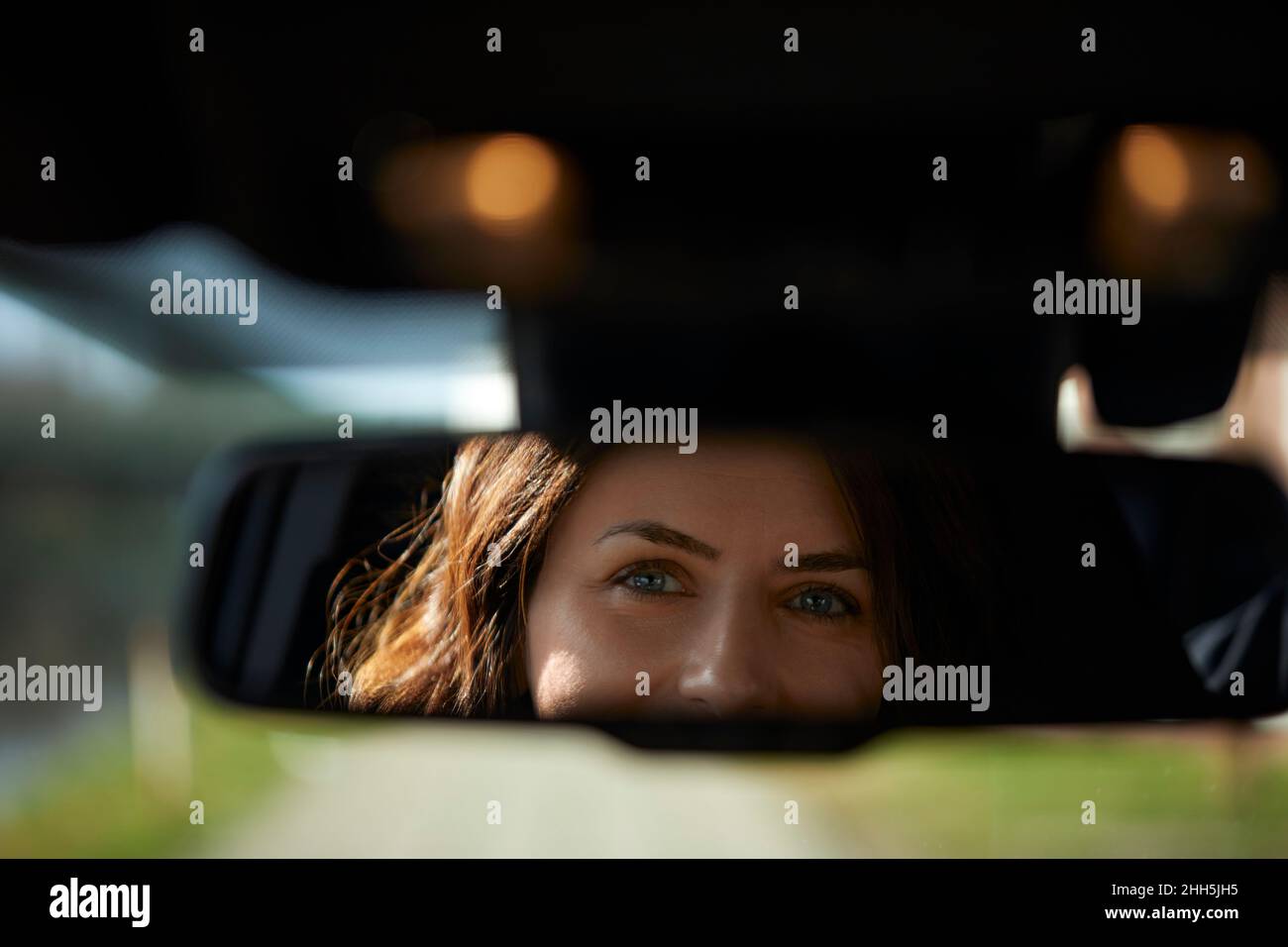 Riflesso della donna d'affari sullo specchietto retrovisore per auto Foto Stock