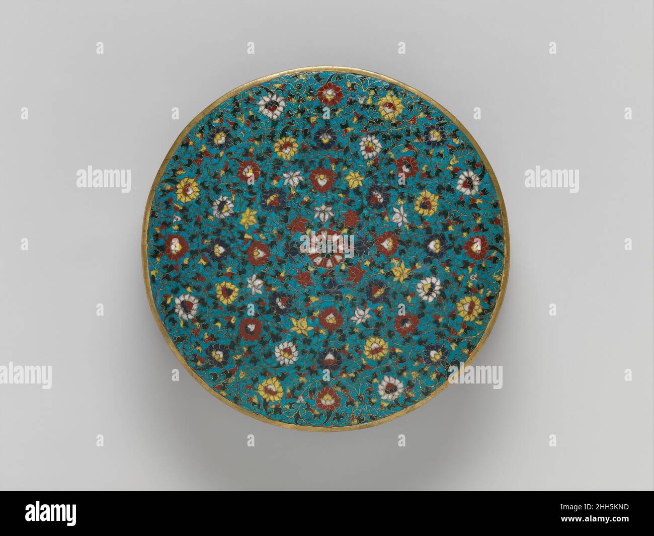 Base per un mandala 15th secolo Cina mandala Ceremonial mandala sono stati utilizzati in forme successive di buddhismo, tra cui il buddismo Esoterico, che fiorì in Tibet dal decimo secolo e fu influente alla corte cinese dopo il quattordicesimo. Questa base un tempo supportava un mandala tridimensionale che probabilmente comprendeva piccole sculture, modelli di templi e stupa, o sabbie colorate. La decorazione combina fiori di loto (simboli buddisti di purezza) in cima con gli otto tesori buddisti ai lati. Base per un mandala. Cina. 15th secolo. Smalto cloisonné. Dinastia Ming (1368–1644). Cloisonn Foto Stock