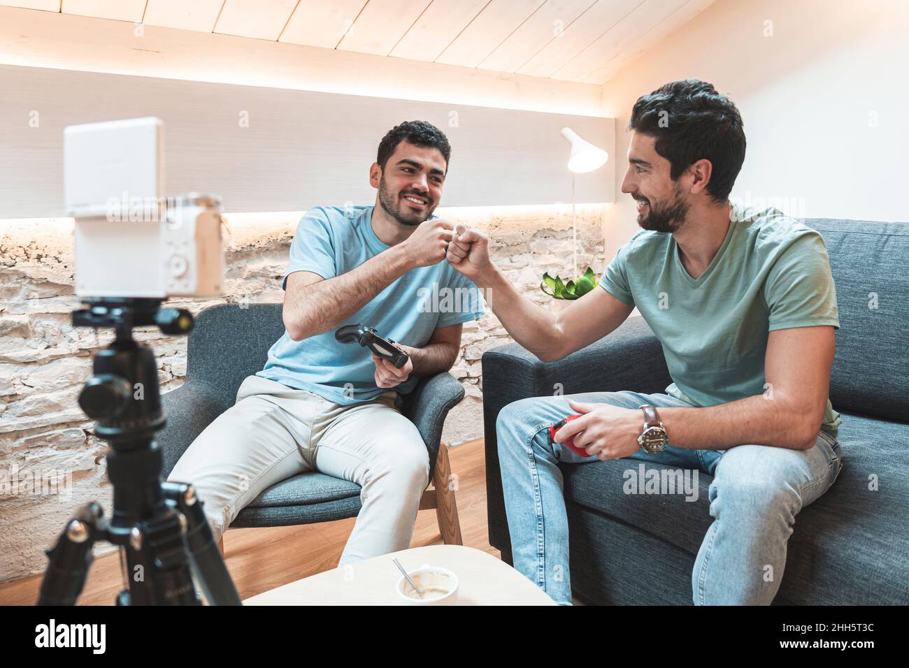 Influencer che danno il pugno scosso sul live streaming vlogging attraverso la fotocamera a casa Foto Stock