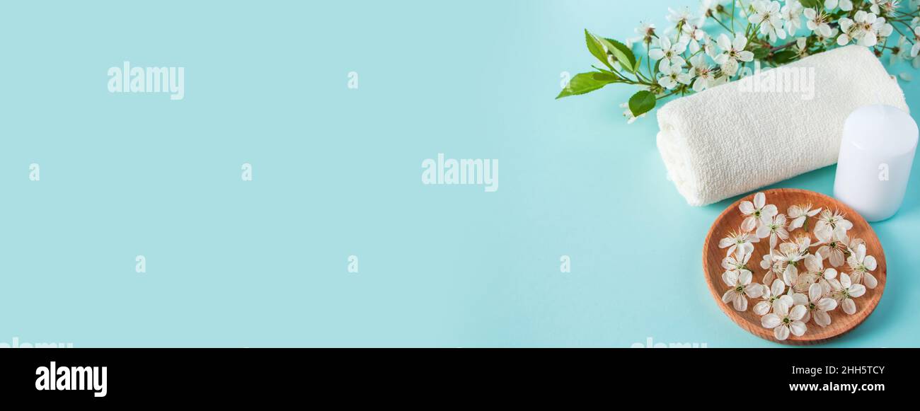 Prodotti naturali biologici di bellezza per spa e aromaterapia. Olio essenziale aromatico, candele e un asciugamano su sfondo blu. Concetto di relax, luogo Foto Stock