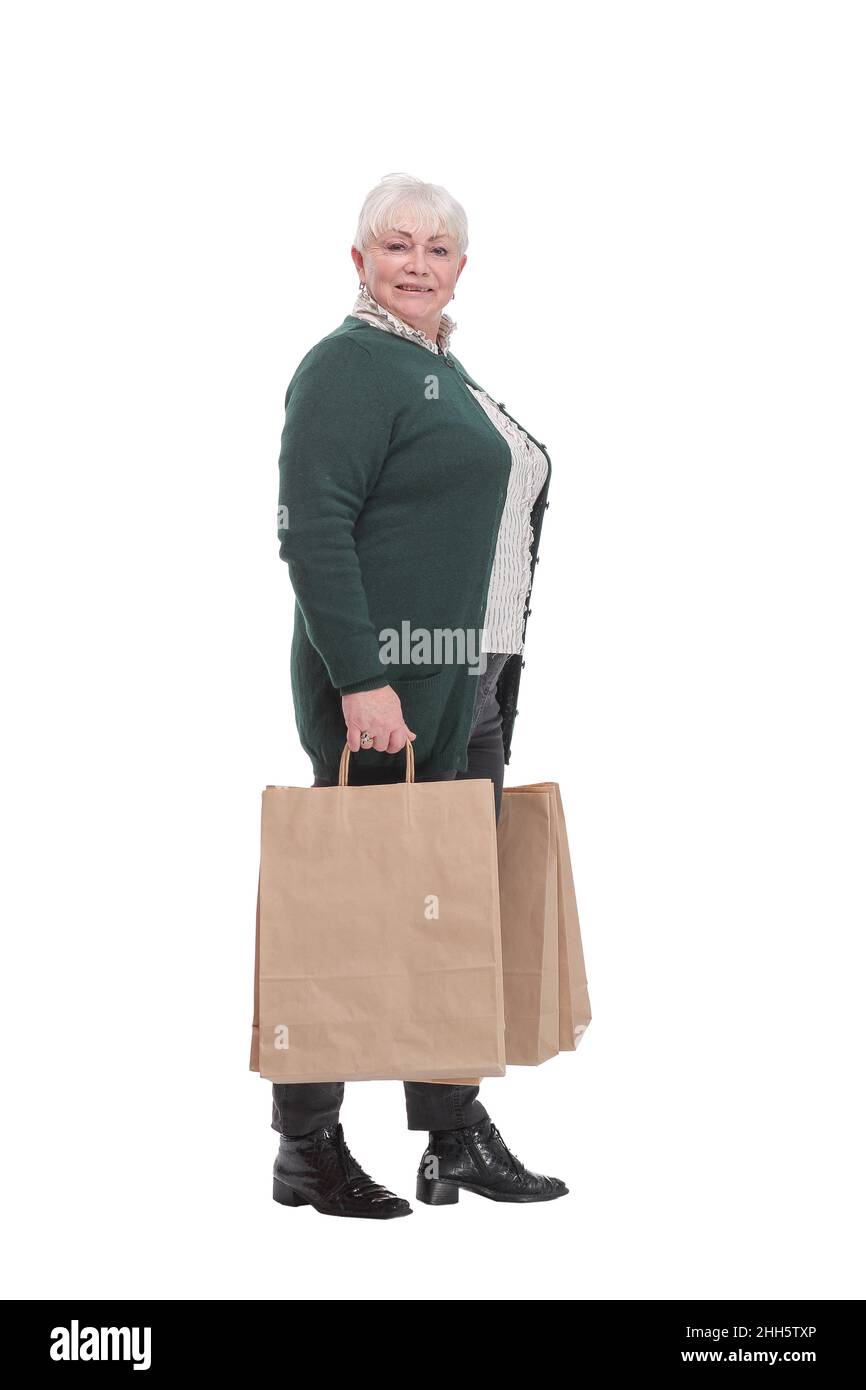 Donna anziana felice che si allunga le mani con i sacchetti di shopping e sorridente mentre sta in piedi isolato su sfondo bianco. Mi piace fare shopping! Foto Stock