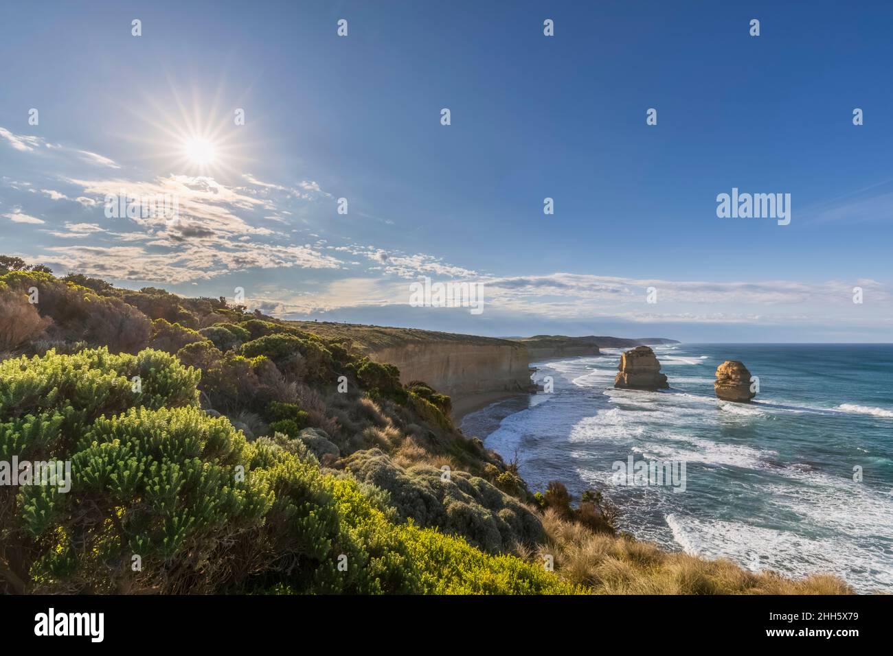 Australia, Victoria, Sun splende sui dodici Apostoli e Gibson Steps nel Parco Nazionale di Port Campbell all'alba Foto Stock