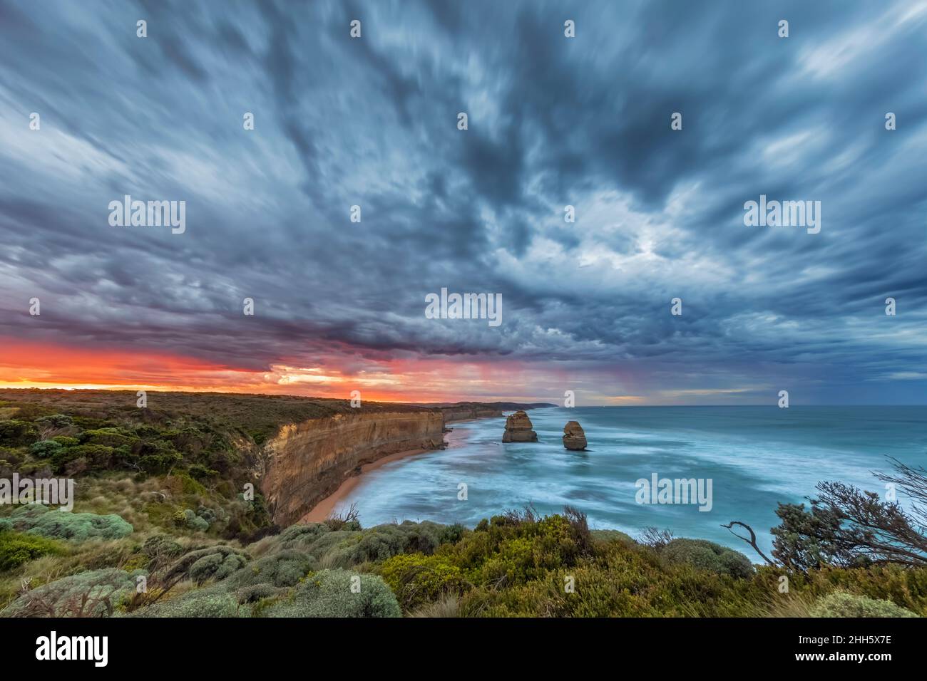 Australia, Victoria, lunga esposizione dei dodici Apostoli e Gibson Steps nel Parco Nazionale di Port Campbell all'alba nuvolosa Foto Stock