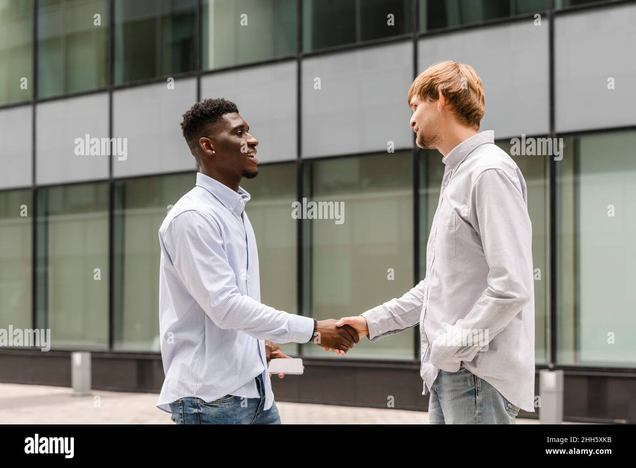 Giovane che fa una stretta di mano con un amico sul sentiero Foto Stock