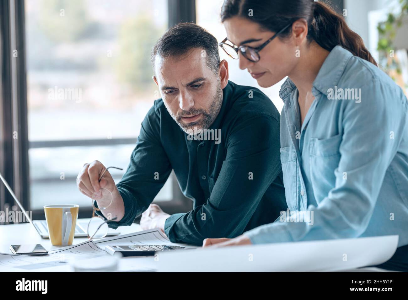 Uomo d'affari che discute di un piano con un collega sul posto di lavoro Foto Stock