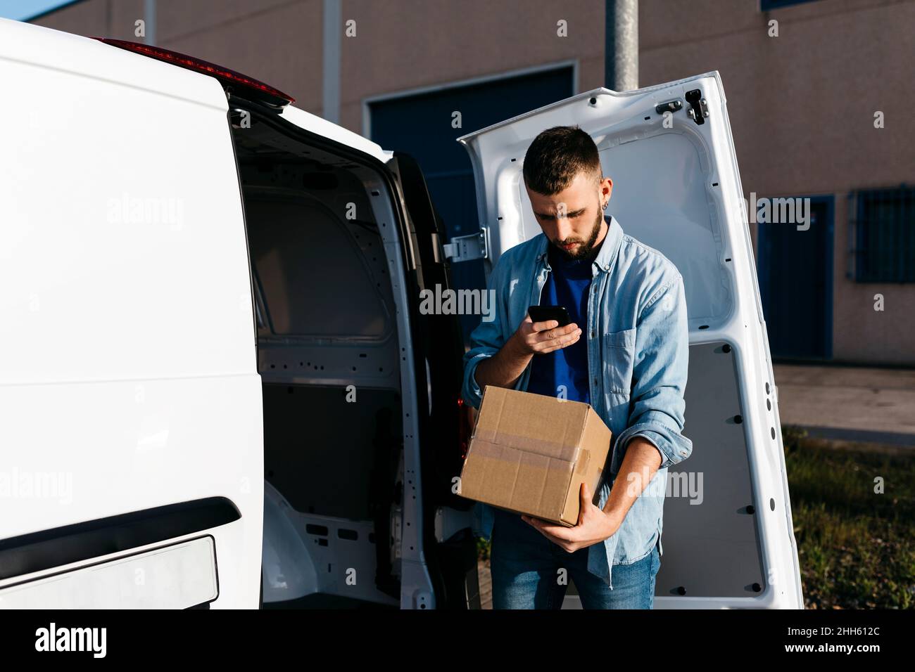 Giovane uomo scansione cassetta di consegna in furgone Foto Stock