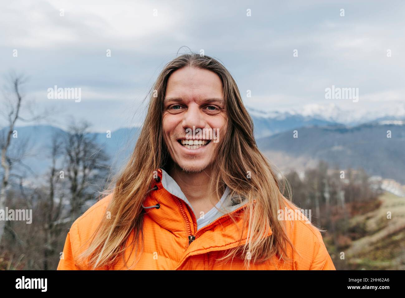Uomo allegro con lunghi capelli biondi Foto Stock