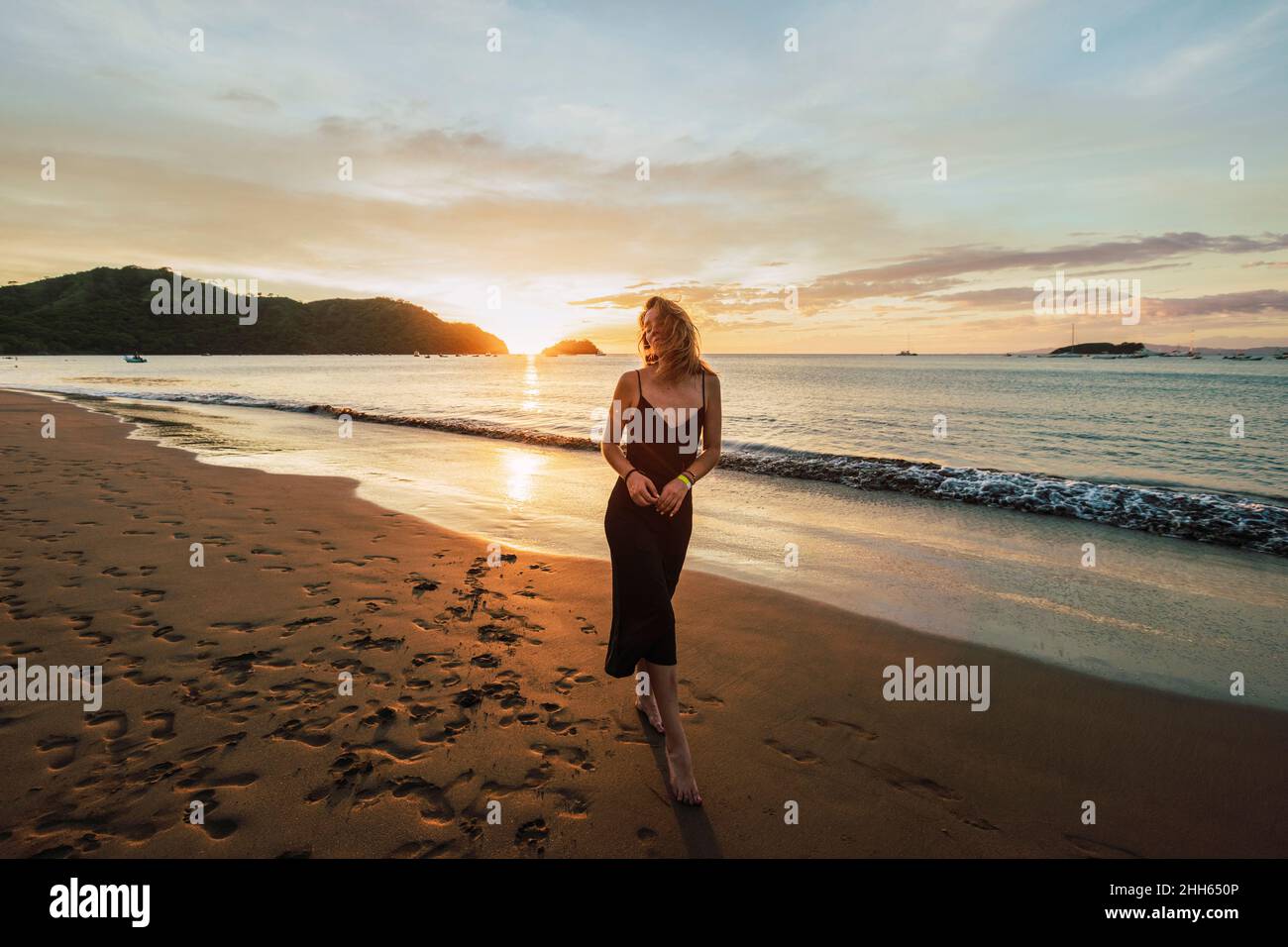 Donna che si gode il tramonto alla spiaggia del Coco, provincia di Guanacaste, Costa Rica Foto Stock