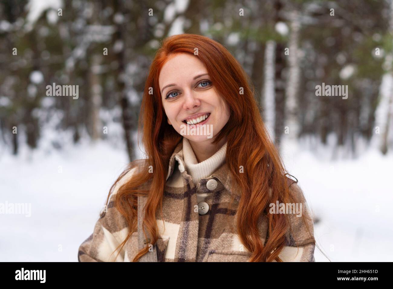Donna rossa felice nella foresta d'inverno Foto Stock
