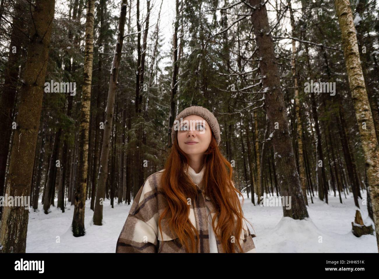 Donna in vacanza giorno sognando nella foresta invernale Foto Stock