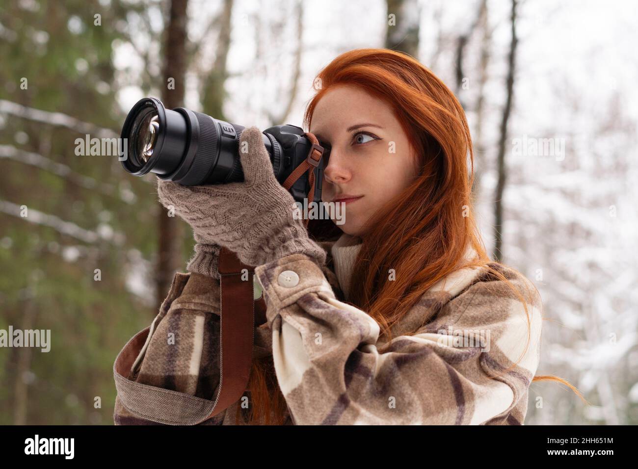 Donna rossa che fotografa con la fotocamera Foto Stock