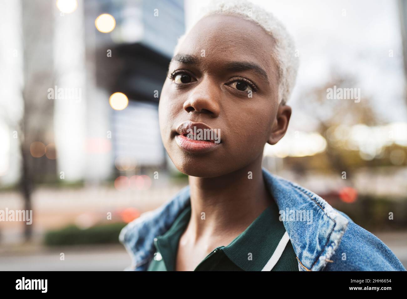 Giovane donna seria con capelli biondi corti Foto Stock