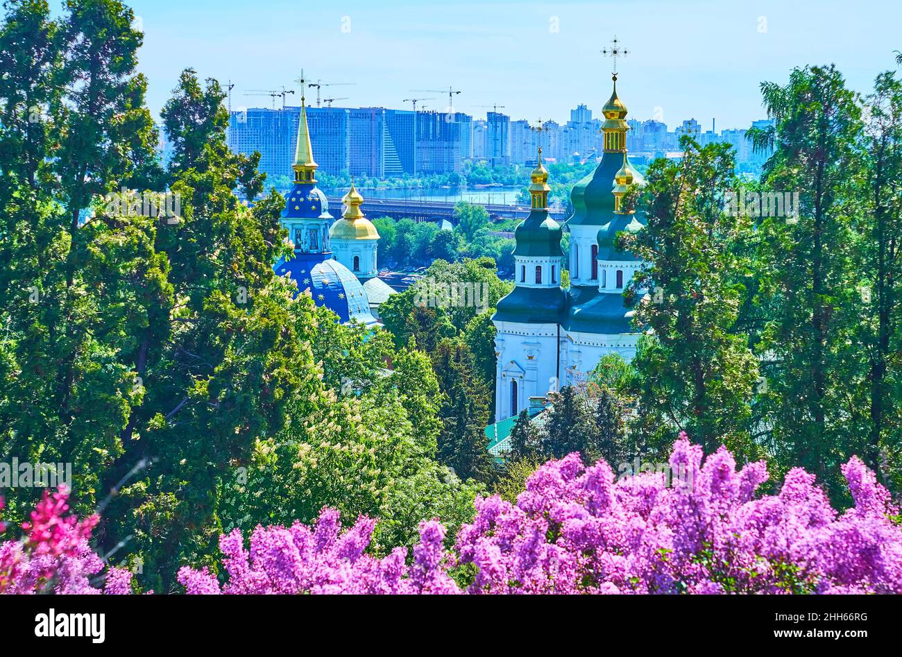 Il paesaggio urbano di Kyiv con abitazioni moderne, il fiume Dnieper, il Ponte nuovo Darnytskyi, il monastero medievale di Vydubychi e il verde della Garde Botanica di Kyiv Foto Stock