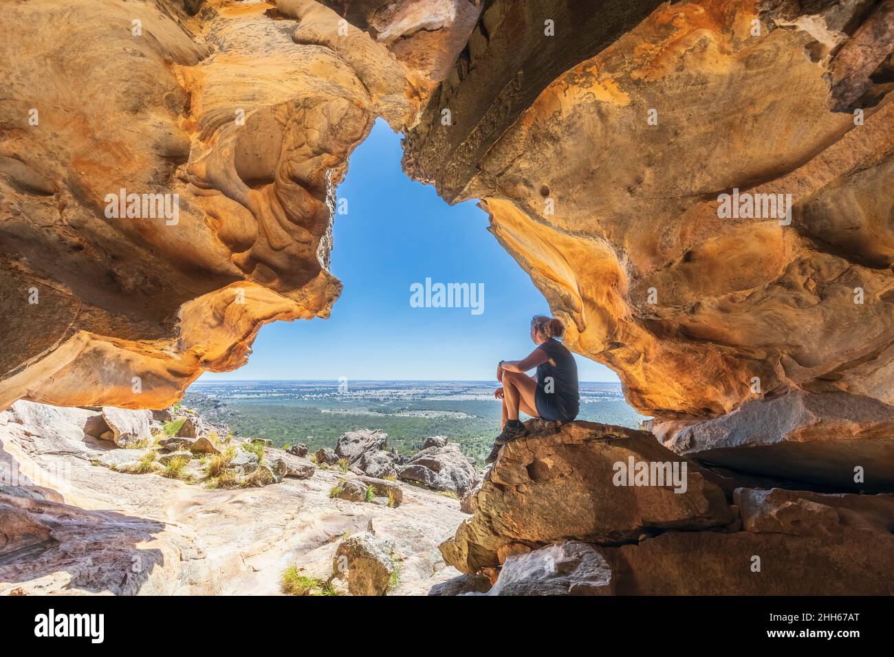 Australia, Victoria, Female turista rilassarsi all'interno della grotta Hollow Mountain nel Parco Nazionale dei Grampians Foto Stock