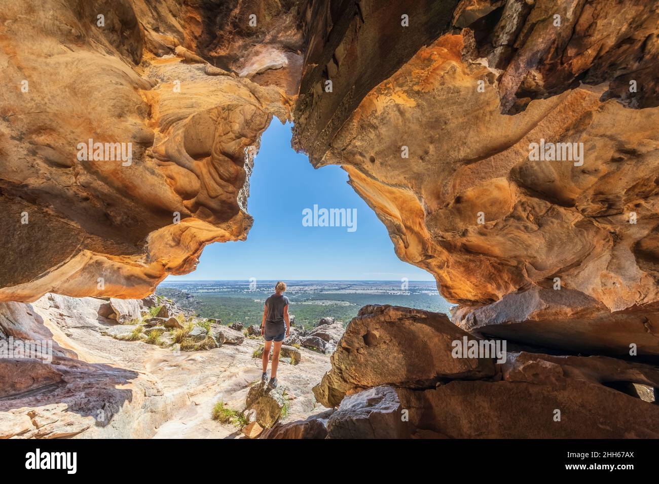 Australia, Victoria, Femminile turista ammirando il paesaggio circostante dall'ingresso della grotta Hollow Mountain nel Parco Nazionale dei Grampians Foto Stock