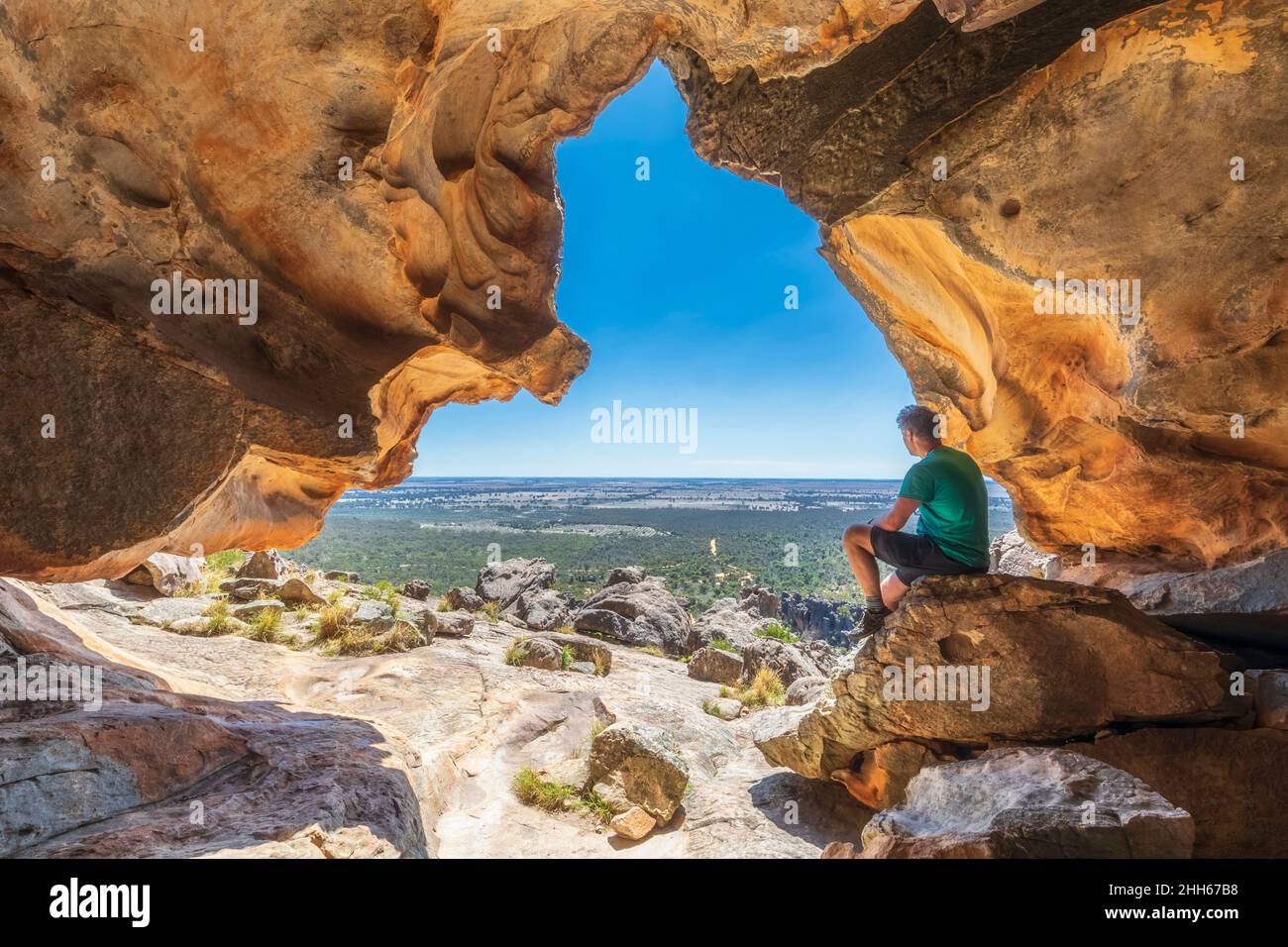 Australia, Victoria, turista maschile rilassante all'interno della grotta Hollow Mountain nel Parco Nazionale dei Grampians Foto Stock