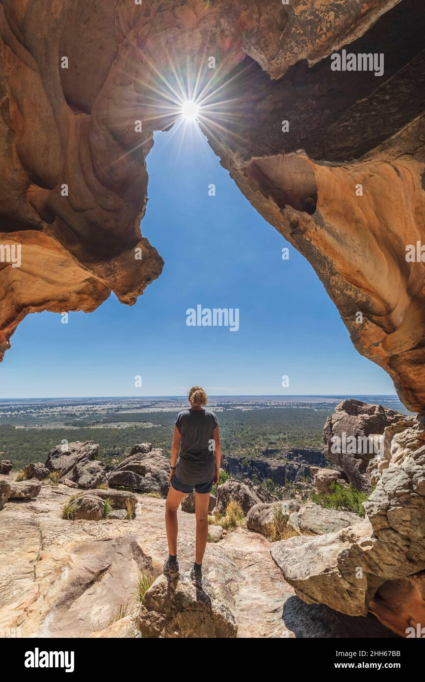 Australia, Victoria, Femminile turista ammirando il paesaggio circostante dall'ingresso della grotta Hollow Mountain nel Parco Nazionale dei Grampians Foto Stock