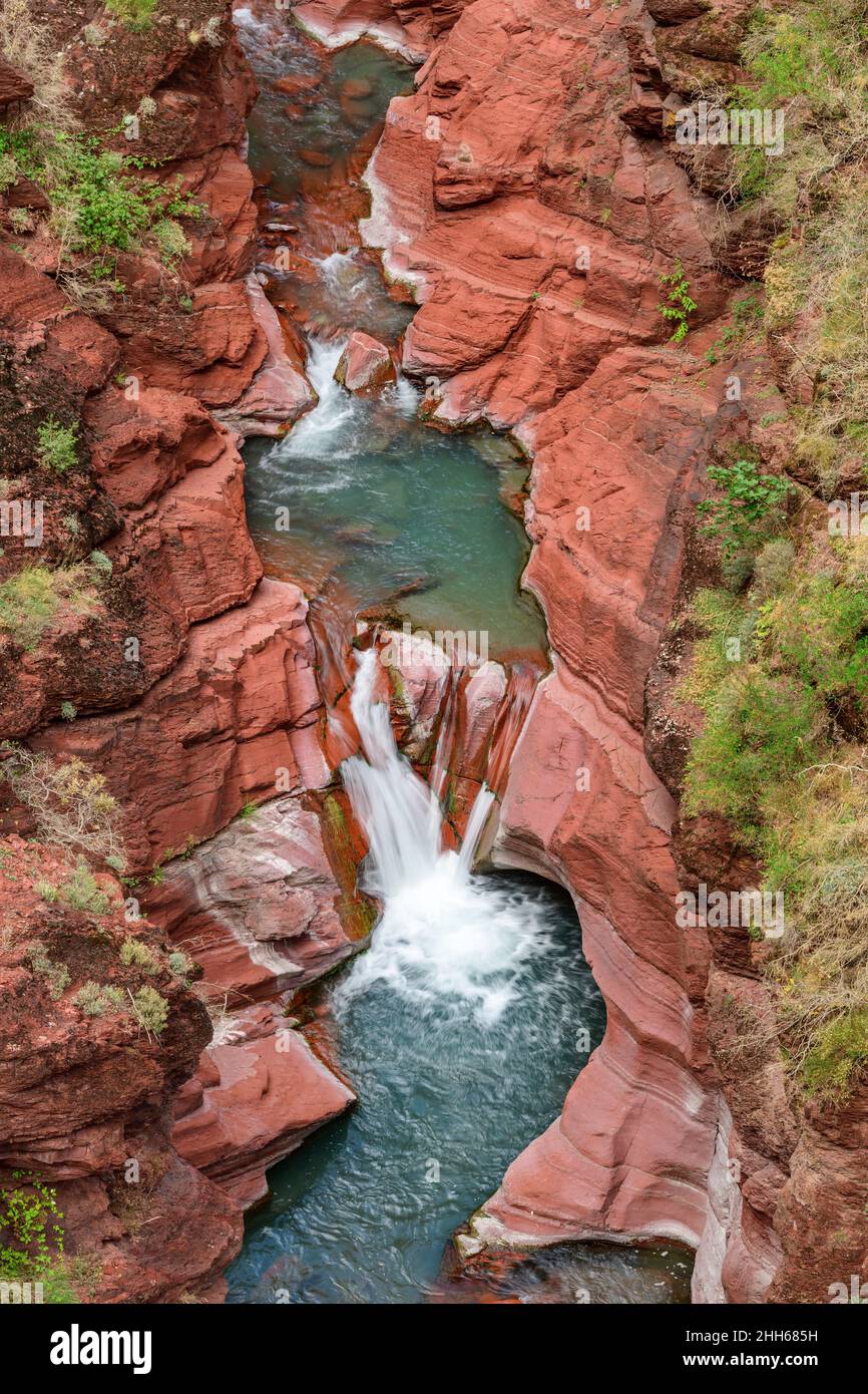 Acqua fluente tra formazioni rocciose rosse delle Alpi Marittime, Parco Nazionale del Mercantour, Francia Foto Stock