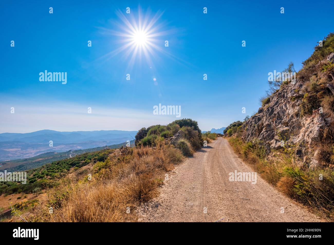 Strada sterrata vuota in montagna in giornata di sole in Andalusia, Spagna, Europa Foto Stock