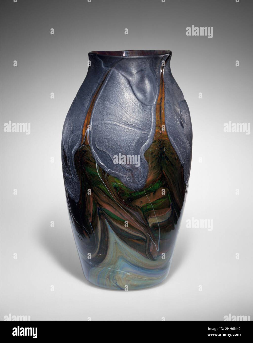 Vaso 1893–96 progettato da Louis Comfort Tiffany American questo oggetto fa parte di un gruppo di oltre quaranta dati al Museo nel 1896 da Louisine e Henry Osborne Havemeyer (96.17.9–.56). Il regalo fu il primo bicchiere americano ad entrare nella collezione del Museo. Molto probabilmente spinto da Louis Comfort Tiffany, gli Havemeyers hanno presentato la loro collezione di vetro di Tiffany Favrile al Museo solo tre anni dopo Tiffany iniziato a produrre decorativi vasi di vetro soffiato. Le forme, i colori e le finiture dei vasi e delle placche di Tiffany si ispirarono al mondo naturale e all'antico vetro. Vaso 9398 Foto Stock