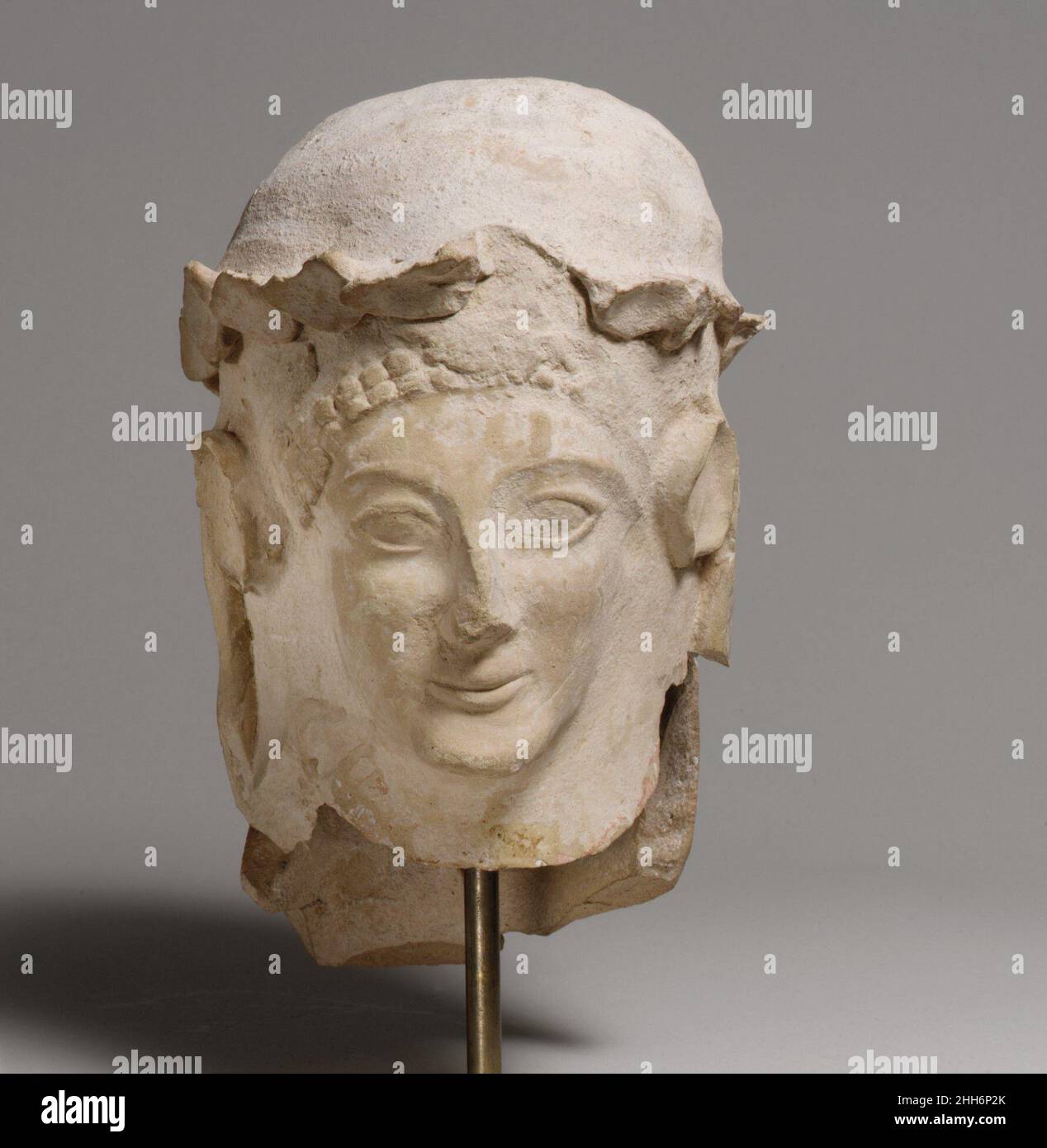 Testa in terracotta con corona ca. 600–480 a.C. Cipriota il capo originariamente indossava una grande corona che ora è più che rotto. Nella scultura calcarea cipriota, le rappresentazioni di figure strane, solitamente maschili, sono uno dei tipi più comuni. Probabilmente hanno a che fare con le osservanze connesse con la fertilità. Questa testa è un bell'esempio in terracotta; sarebbe stata parte di una statua a tutta lunghezza. Testa in terracotta con corona 241006 Foto Stock