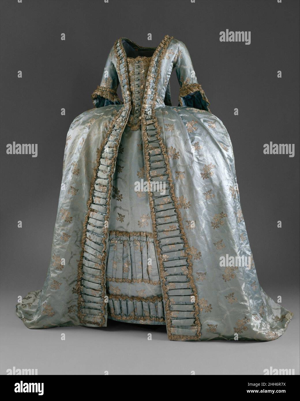 Robe à la Francaise ca. 1765 europeo come il Mantova, il sacco, o sacque, vestito ha iniziato la vita come un abito informale. Inizialmente era una moda francese, la sua caratteristica distintiva era la fila di due pieghe doppie cucite al centro della scollatura sul retro del vestito e che cadono fino all'orlo. La prima forma della abito era sciolta e non strutturata, cadendo dalle spalle in una forma a campana. Questo ha evocato molti commenti sul potenziale di comportamento immorale, con le conseguenze nascoste in modo sicuro dalla camoscio voluminosa. Un sacco era sempre indossato sopra le stays (un corset) e gradualmente lo stile Foto Stock