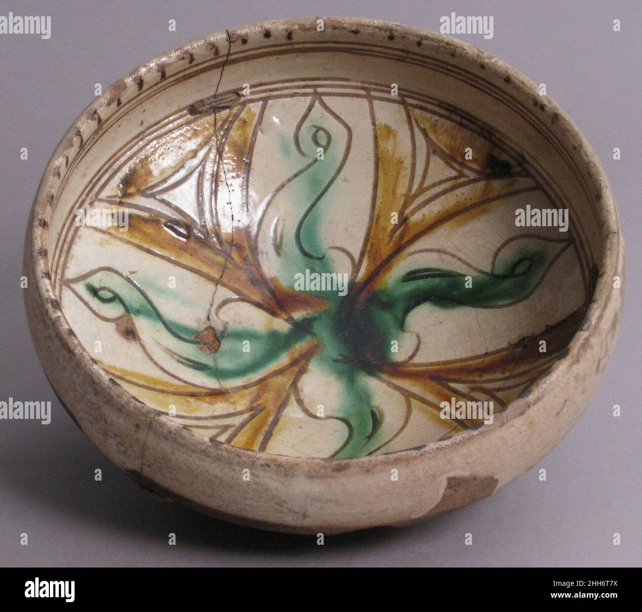 Ciotola 12th–13th secolo bizantino nonostante le loro relazioni politiche spesso bellicose, la tecnologia della ceramica e altre tradizioni culturali hanno collegato l'impero bizantino e il mondo islamico. Questa ciotola fu influenzata da opere simili prodotte nel primo mondo islamico. Le corde sulla ciotola sono state aggiunte durante il restauro. Recipiente 463404 Foto Stock