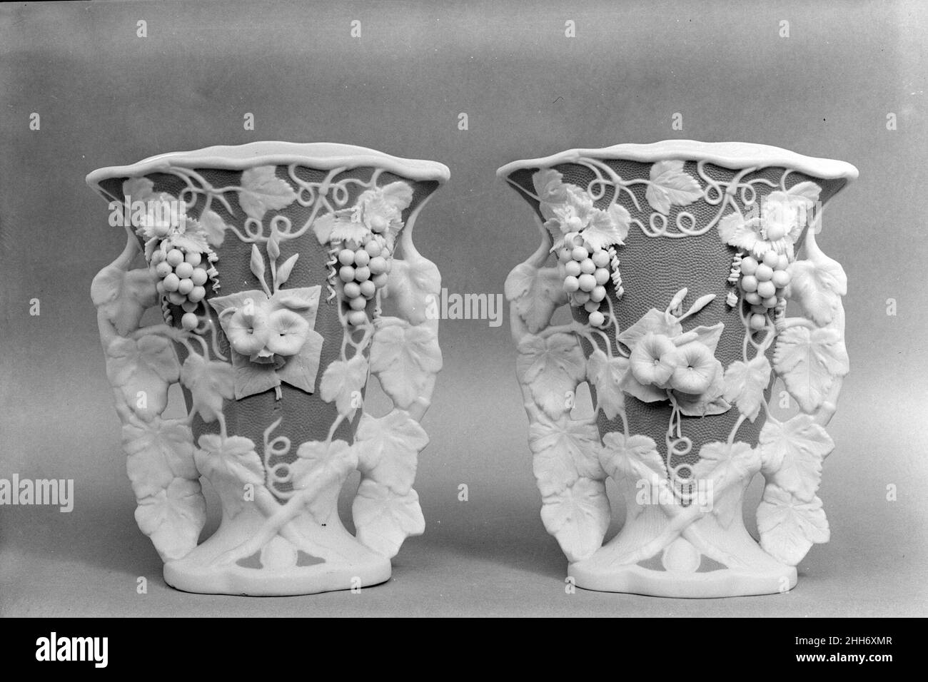 Vaso 1830–70 americano chiamato in riferimento all'antica cava di marmo sull'isola greca di Parros, parian ha una proporzione maggiore di feldspare rispetto alla porcellana convenzionale, dando luogo ad un corpo di biscotto vetrificato che assomiglia al marmo bianco di statuaria. Elegante e accessibile, statue e oggetti da toletta di parian erano ornamenti di famiglia estremamente popolari nella metà del diciannovesimo secolo. Questo vaso (uno di un paio, 47.90.34) è stato probabilmente fatto dalla United States Pottery Company, che ha esposto parian a grande acclamazione alla New York Crystal Palace Exhibition 1853 a New York. Vaso. Americano. 1830–70. Parian Foto Stock