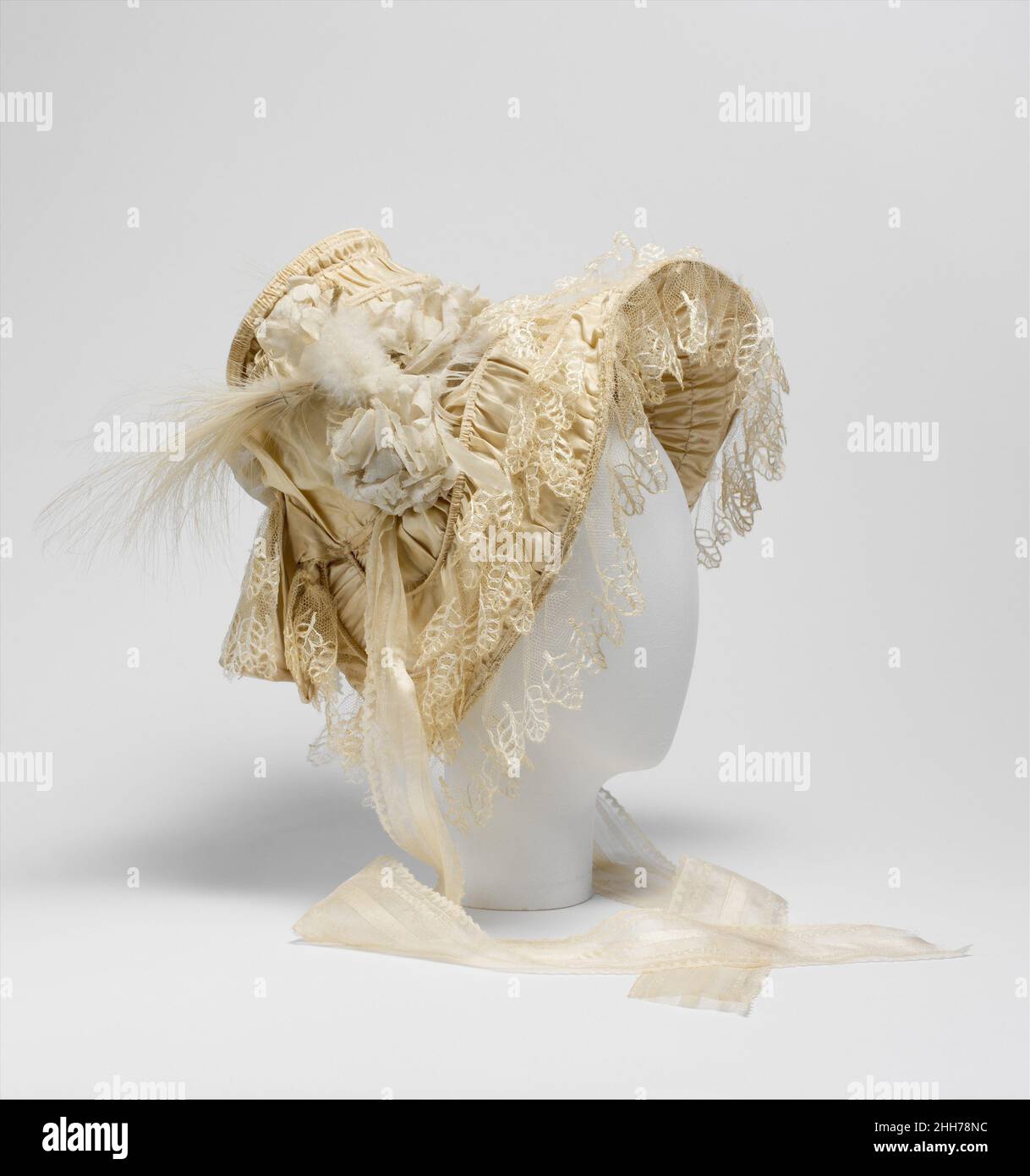Cofano 1830–35 Francese nel 1830s il coiffeur alla moda è stato tirato indietro i capelli in un alto chignon singolo o doppio anello con fitti grappoli di ricci alle tempie. Questa acconciatura influenzò il profilo dei cappelli del periodo, che erano caratterizzati da corone strette, profonde, cilindriche che erano angolate verso l'alto, e larghe, viso incorniciante, brimi halolike. I rivestimenti del cappello erano particolarmente sontuosi, con gli interni delle bride, perché erano esposti, anche trattati decorativamente. Questo esempio è particolarmente ricco di ornamenti e raro per la sopravvivenza di tutti i suoi abbellimenti. Cofano Foto Stock