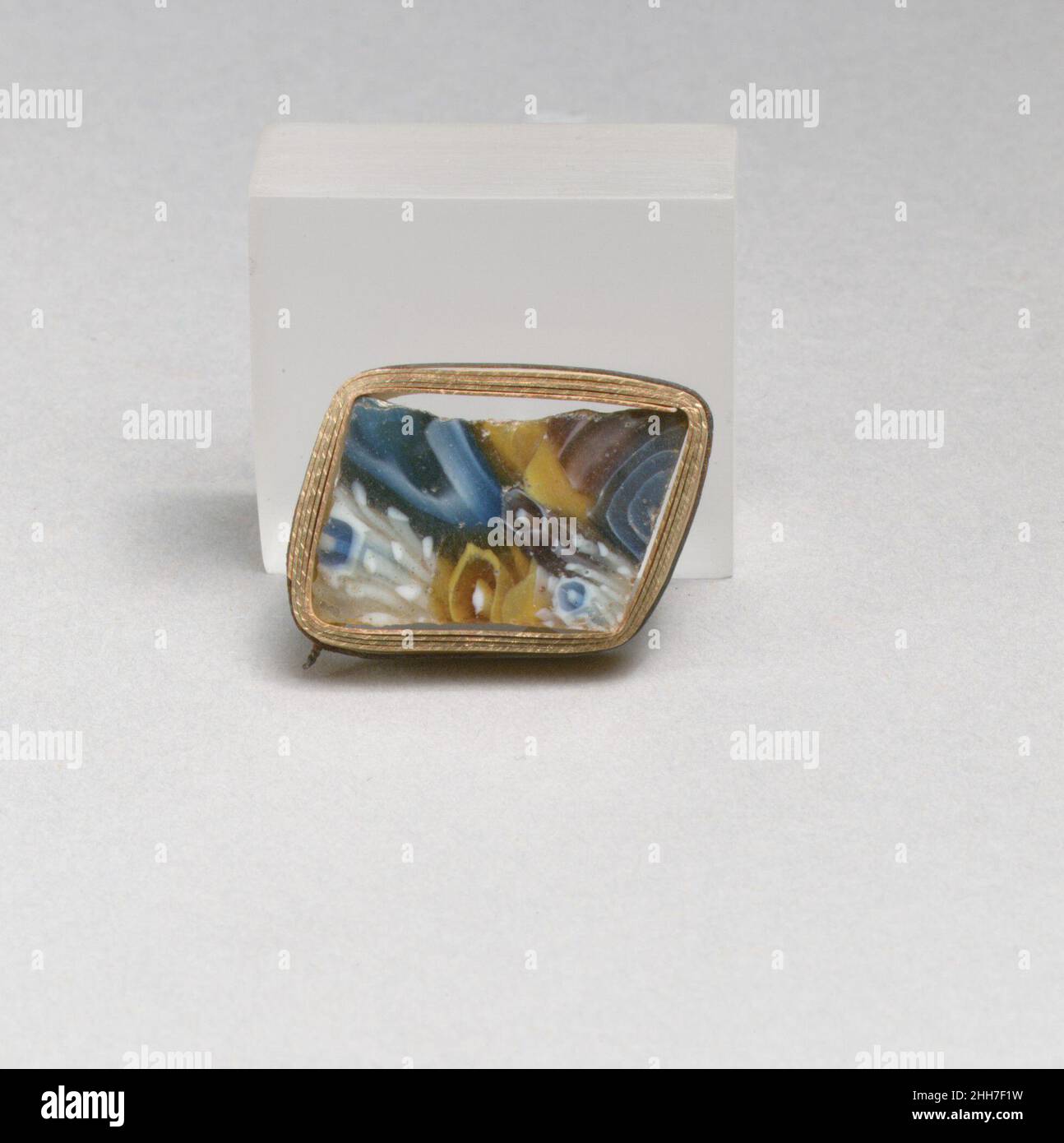 Frammento di mosaico di vetro fine 1st secolo a.C.–inizio 1st secolo d.C. romano frammento di corpo a pareti sottili.viola traslucido, blu cobalto, marrone miele che appare giallo, bianco opaco e incolore.curvatura convessa poco profonda side.Composite motivo di mosaico formato da sezioni poligonali di quattro canne: una in viola con un cerchio bianco e un'asta centrale bianca; l'altra in marrone con un cerchio bianco e un'asta centrale bianca; un terzo in un terreno incolore punteggiato di verghe bianche intorno ad un cerchio bianco che racchiude una terra blu con un'asta centrale bianca, e il quarto in un terreno blu con una sp bianca Foto Stock