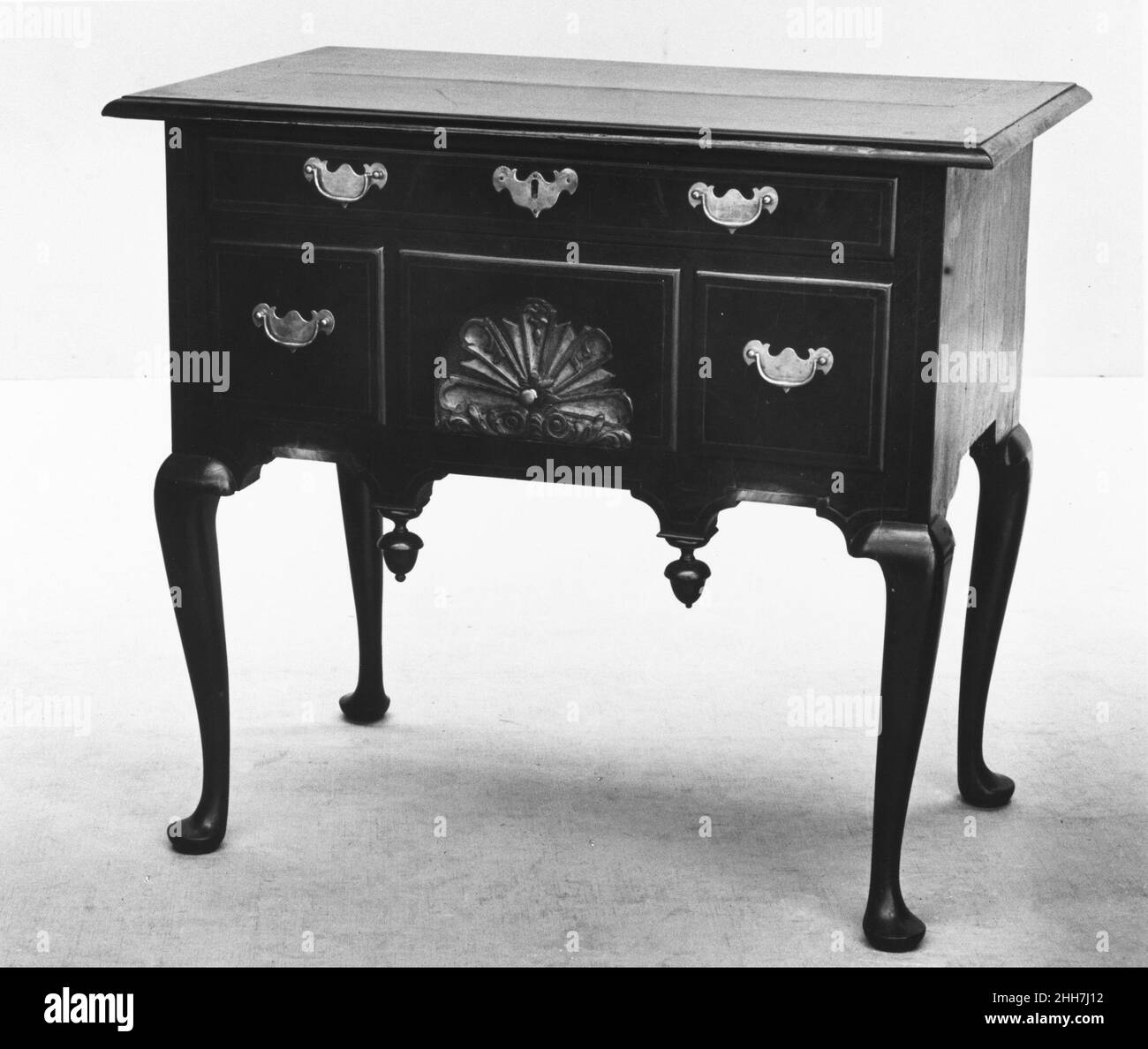 Tavolo da toletta 1730–60 americano nel 1730s, i cabriole di Boston trasformarono il tradizionale petto alto in stile William e Mary a forma di collo piatto, a gamba trasformata, nella versione regina Anne a scroll-top, cabriole-leg. I migliori esempi di questo disegno unico americano, come questo tavolo da toletta e il relativo alto petto (10.125.62), hanno intagliato e dorato conchiglie e delicate stelle della bussola intarsiato sul frontone e sul lato della cassa. Tavolo da toletta. Americano. 1730–60. Impiallacciatura di noce, noce, pino bianco. Fabbricato a Boston, Massachusetts, Stati Uniti Foto Stock