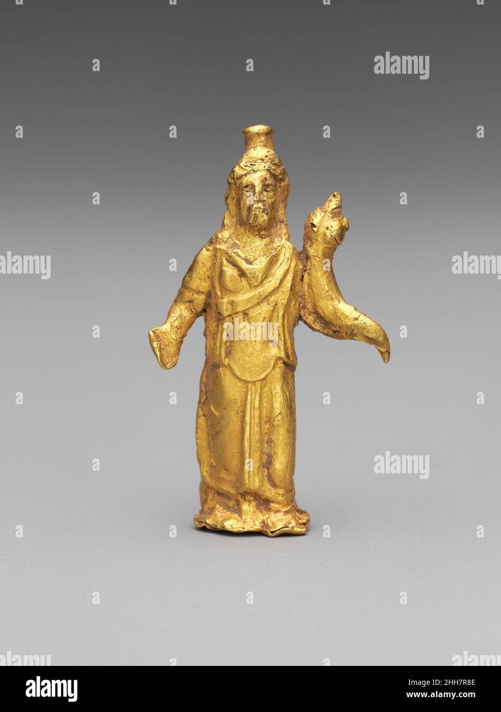 La statuetta d'oro di Zeus Serapis 2nd secolo d.C. il serapis romano era essenzialmente un costrutto dei governanti greci tolemaici dell'Egitto, una conflazione degli dei locali Osiride e Apis. Anche se gradualmente sommerso nel culto pervadente di Iside, Serapis fu adorato in tutto il mondo romano sotto la veste di Zeus, governatore dei cieli, o di Odes, dio degli Underworld. Questa piccola figura indossa il modius egiziano (misura del grano) headdress e porta una cornucopia (corno di abbondanza) per simbolizzare un'abbondanza di cibo. Statuetta d'oro di Zeus Serapis. Romana. 2nd secolo d.C.. Oro. Med-Impe Foto Stock