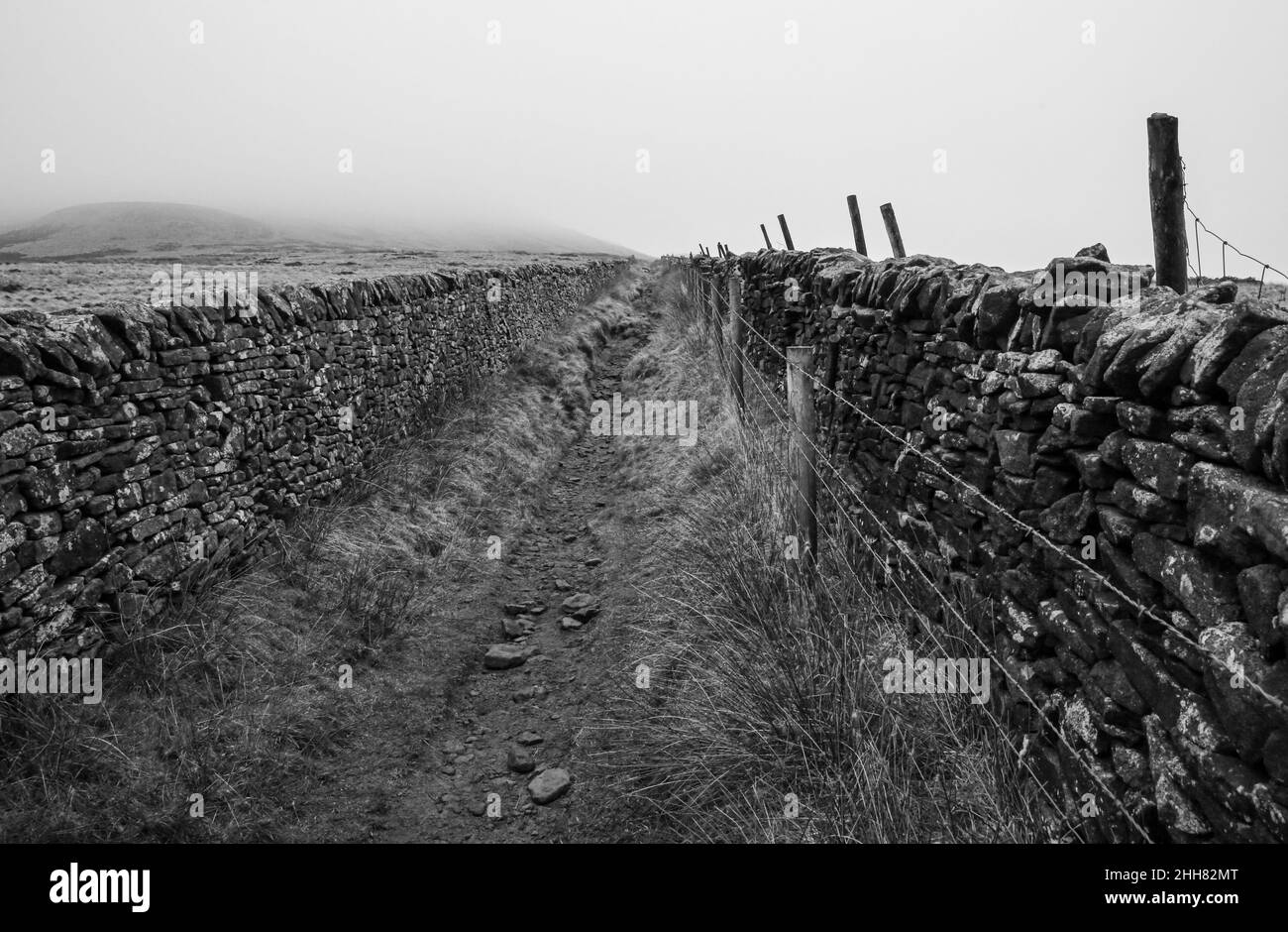 Un sentiero desolato e nebbia nella campagna inglese, Peak District. Foto Stock