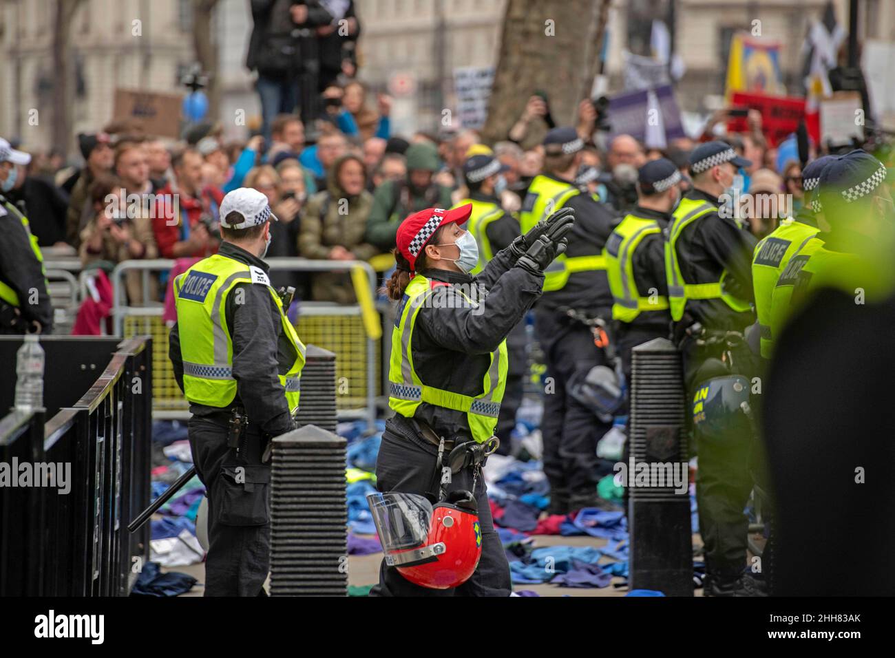 March for Freedom, London, UK - 22nd January 2022 ufficiale di polizia che dice alla folla di calmarsi mentre circondato da divise NHS scartate gettate sopra Foto Stock