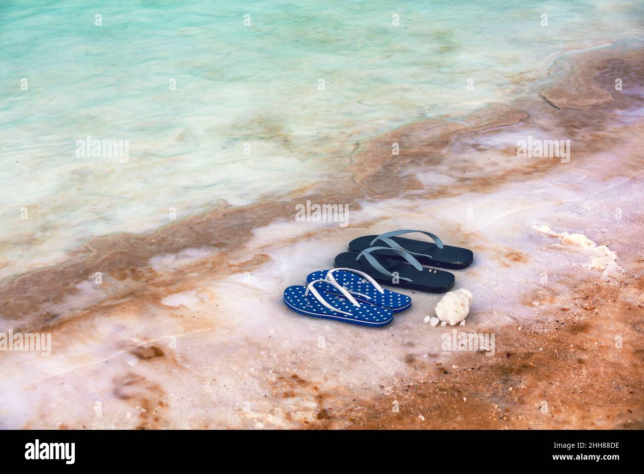 Spiaggia scena Dead SEA Shore. Sandali flip flop femmina e maschio sulla spiaggia Foto Stock