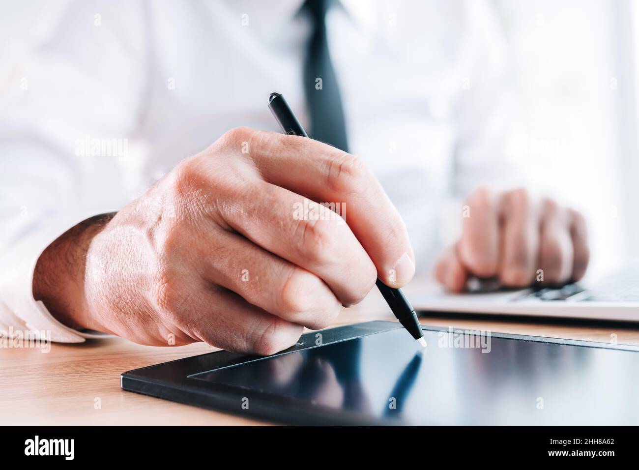 Firma elettronica digitale o concetto di firma elettronica, primo piano della mano firmataria maschile con stilo e pad, fuoco selettivo Foto Stock