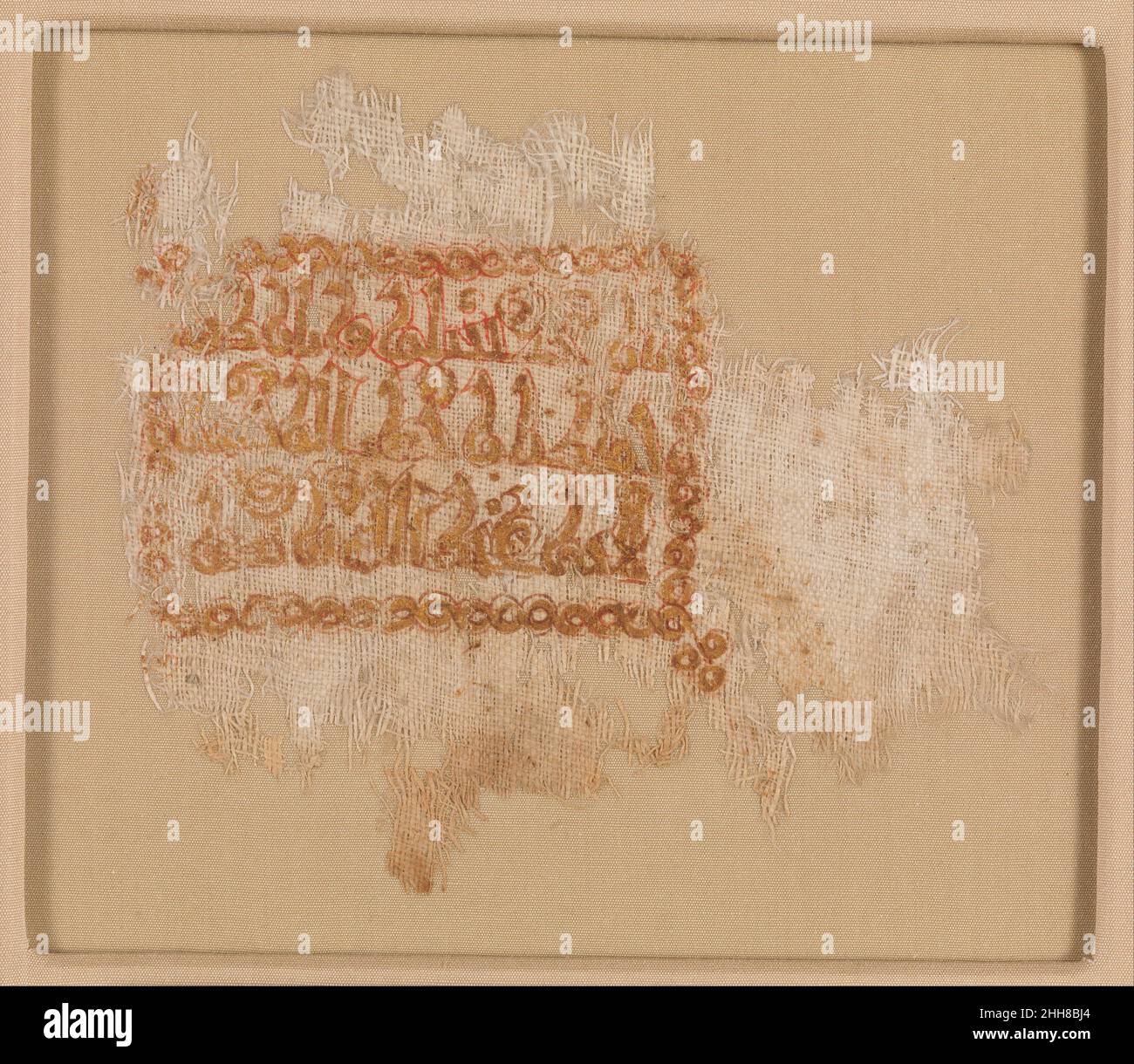 Frammento tessile con Iscrizione 10th–11th secolo solo la porzione inscritta di questo tessuto è sopravvissuta. La scritta kufica e il bordo interlacciato che incornicia l'iscrizione sono stati stampati in oro e delineati in rosso. La frase benedictoria si trova comunemente su oggetti in tutto il mondo islamico, spesso con il nome del destinatario, come è il caso qui. Non si sa nulla del proprietario, Abu ‘Abdallah ibn Nasr, ma probabilmente apparteneva alla classe media per permettersi un oggetto così personalizzato. La forma e le piccole dimensioni dell'iscrizione possono indicare che il frammento era originariamente parte Foto Stock